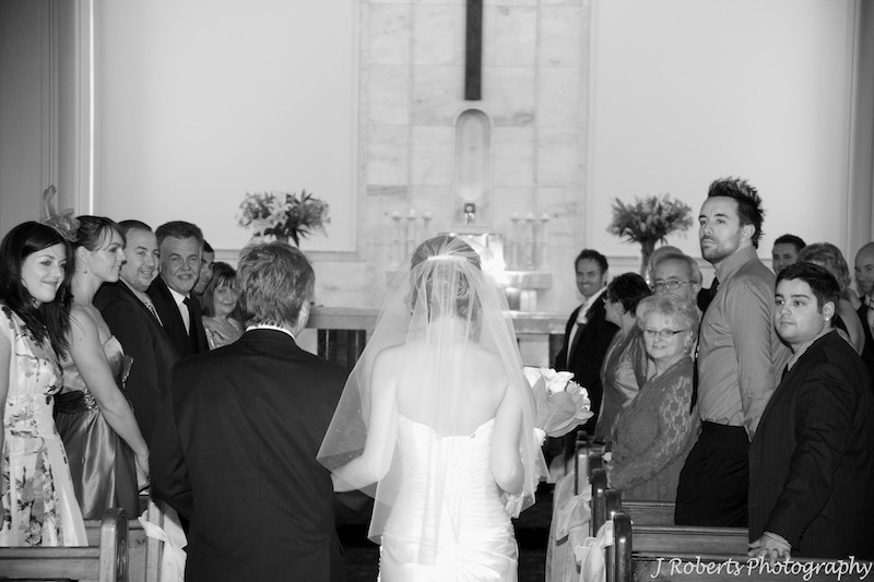 Bride walking down aisle and groom watching - wedding photography